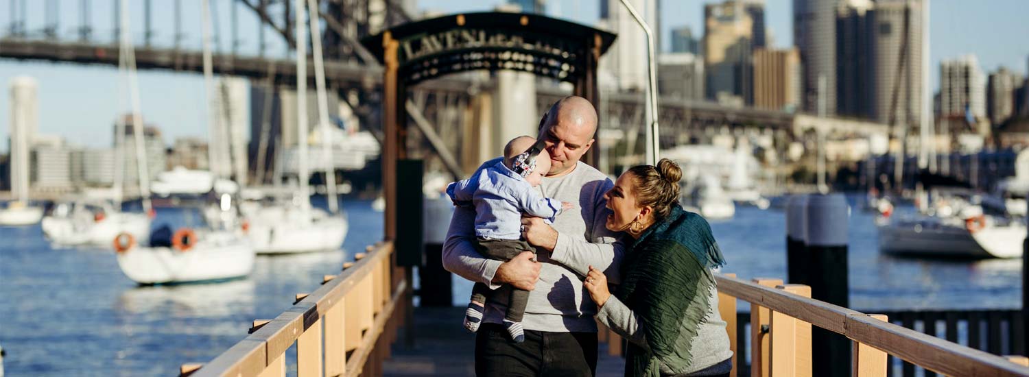 Family standing by Sydney Harbour Bridge in Australia
