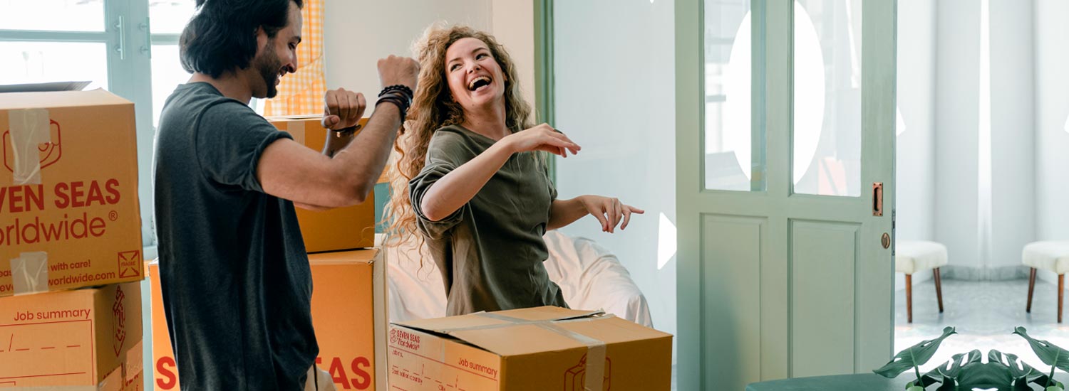 Smiling couple packing boxes
