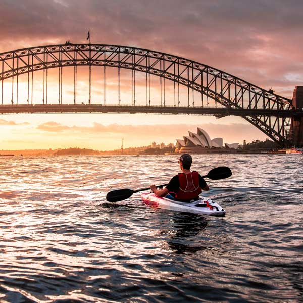 Man canoeing under Sydney Bridge