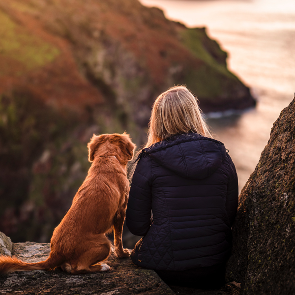 Woman and dog on a cliff