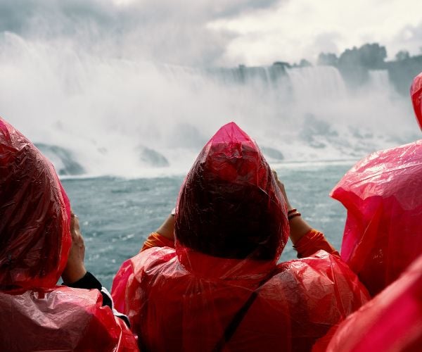 People in red rain macs watching Niagara Falls