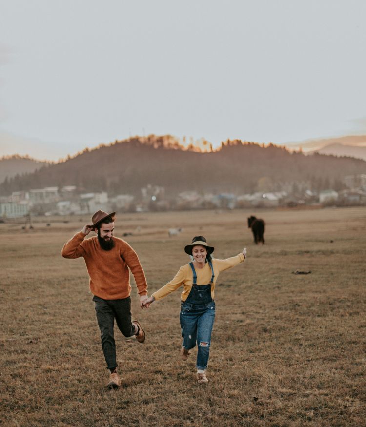 Smiling people running through a field