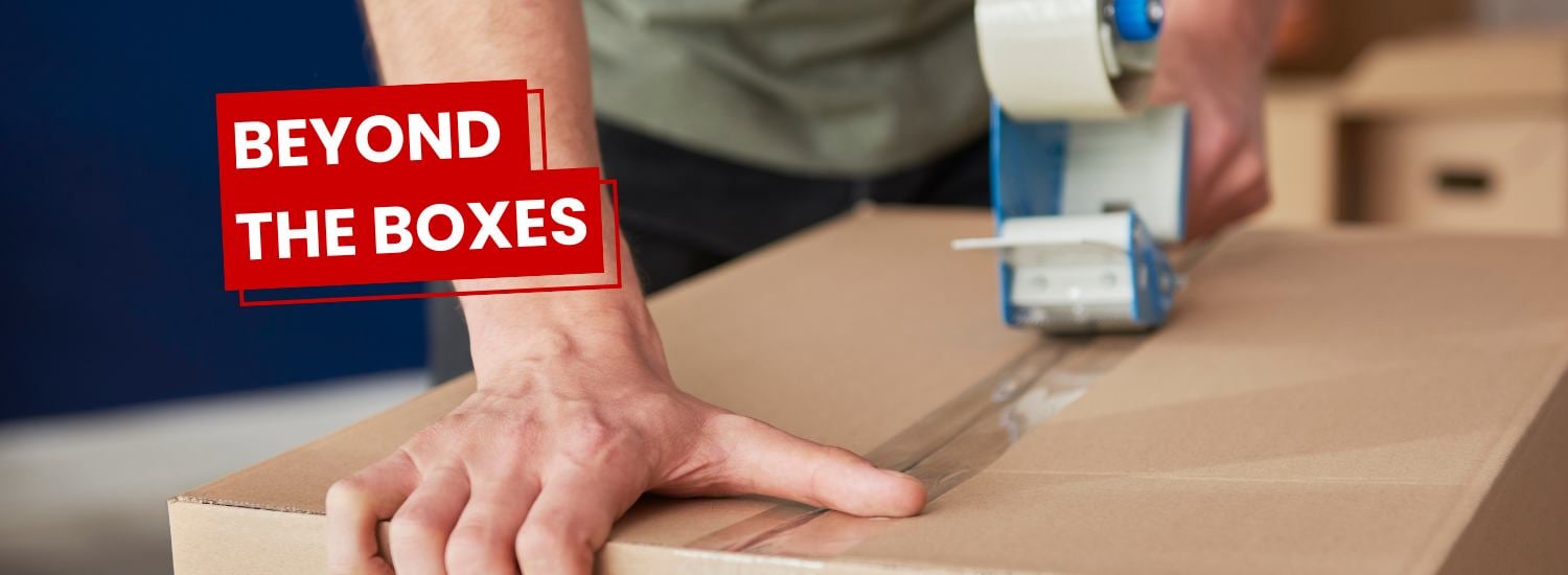 Man sealing a cardboard box with a tape gun with the Beyond the Boxes logo