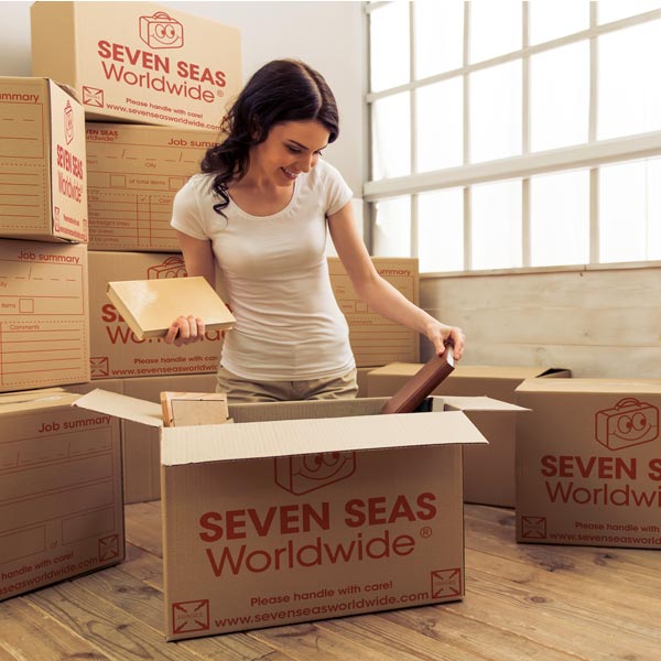 Woman packing books into boxes for shipping