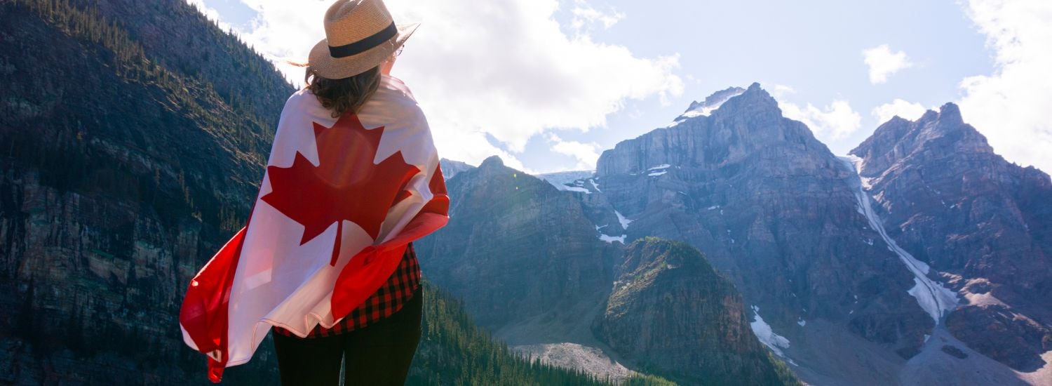Woman wearing a Canadian flag in the mountains