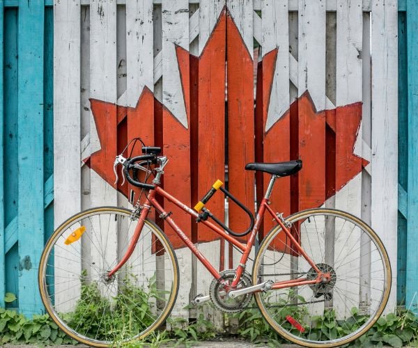 Bike against a fence painted with the Canadian flag