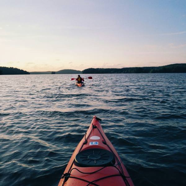 People canoeing on a lake in Finland at dusk