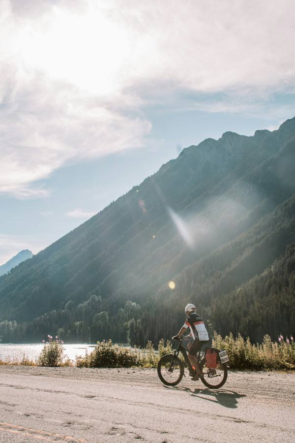 A man riding an e-bike down a dirt road