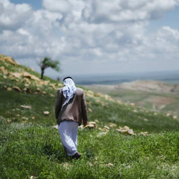 Person walking through grass on a mountain in Iraq