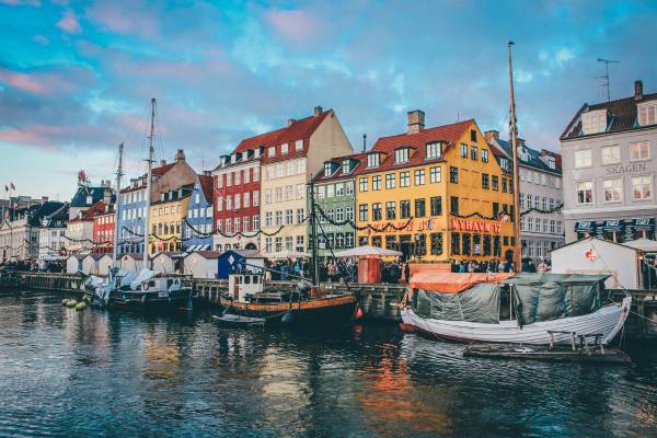 Boats on a river next to a row of colourful buildings in Copenhagen, Denmark