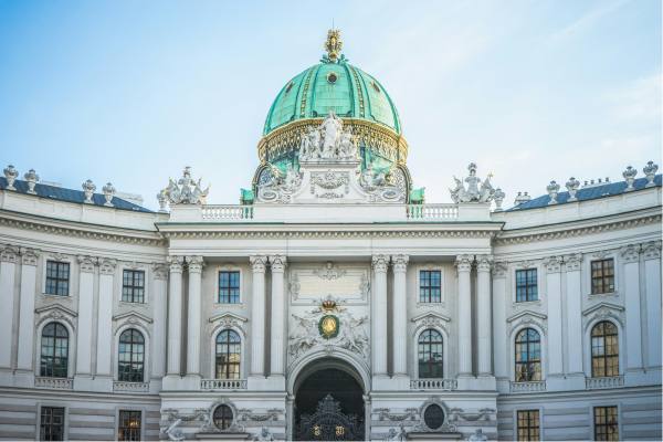A large white palace with a green dome in Vienna, Austria