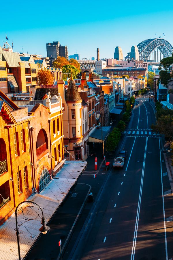 Street and historic buildings in The Rocks, Sydney, with the Harbour Bridge in the background