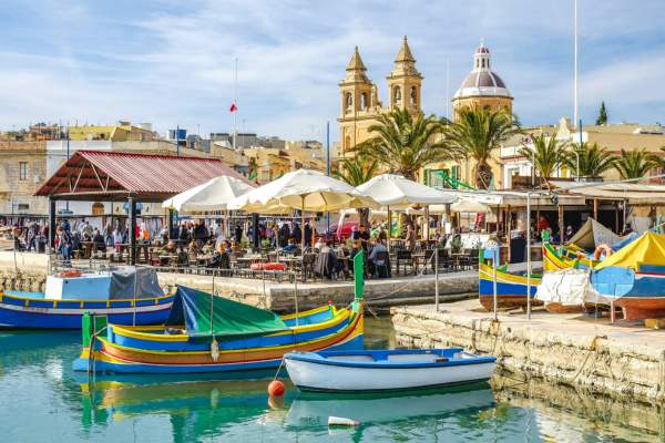 Colourful boats beside a market in Malta