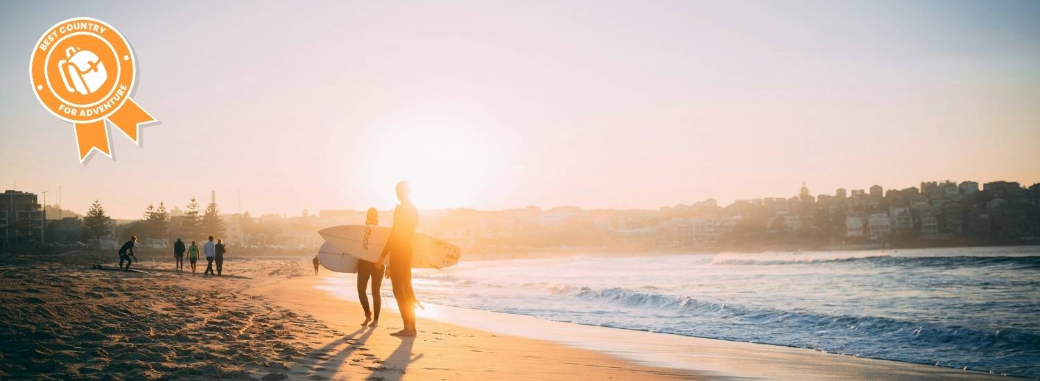 Surfers on a beach in Australia at sunset