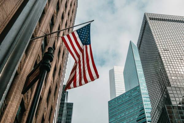 American flag flying from a building next to skyscrapers in New York, USA