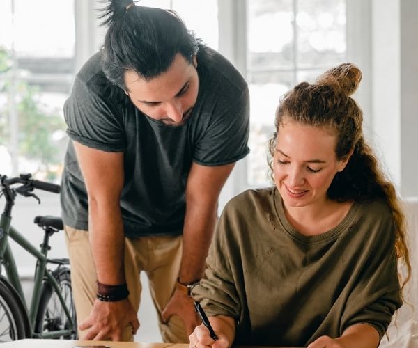 Couple completing a packing list beside a bicycle during an international move